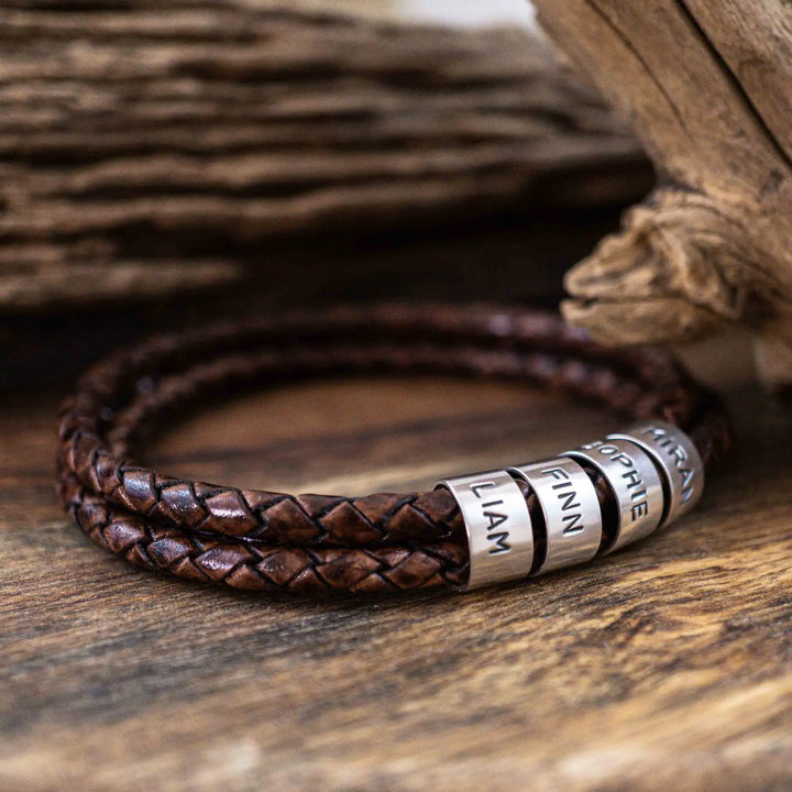 Ein geflochtenes Armband aus braunem Leder im Wickelarmband Look, personalisiert mit Namen Gravur auf Sterling Silber 925 Perlen. Das Armband lässt sich mit einem Karabiner aus Edelstahl verschließen.