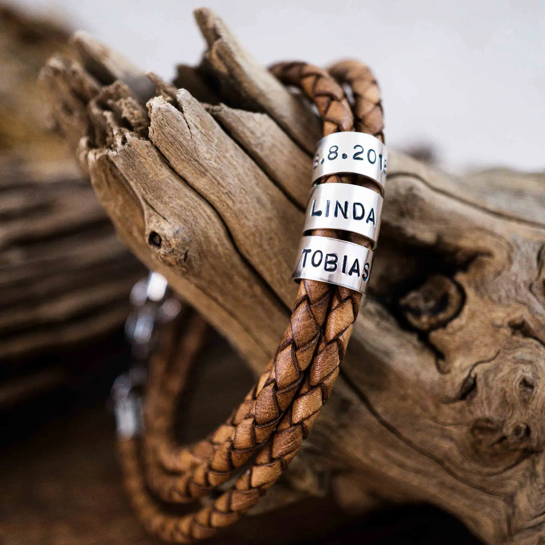 Ein geflochtenes Armband aus hellem braunem Leder im Wickelarmband Look, personalisiert mit Namen Gravur auf Sterling Silber 925 Perlen. Das Armband lässt sich mit einem Karabiner aus Edelstahl verschließen.