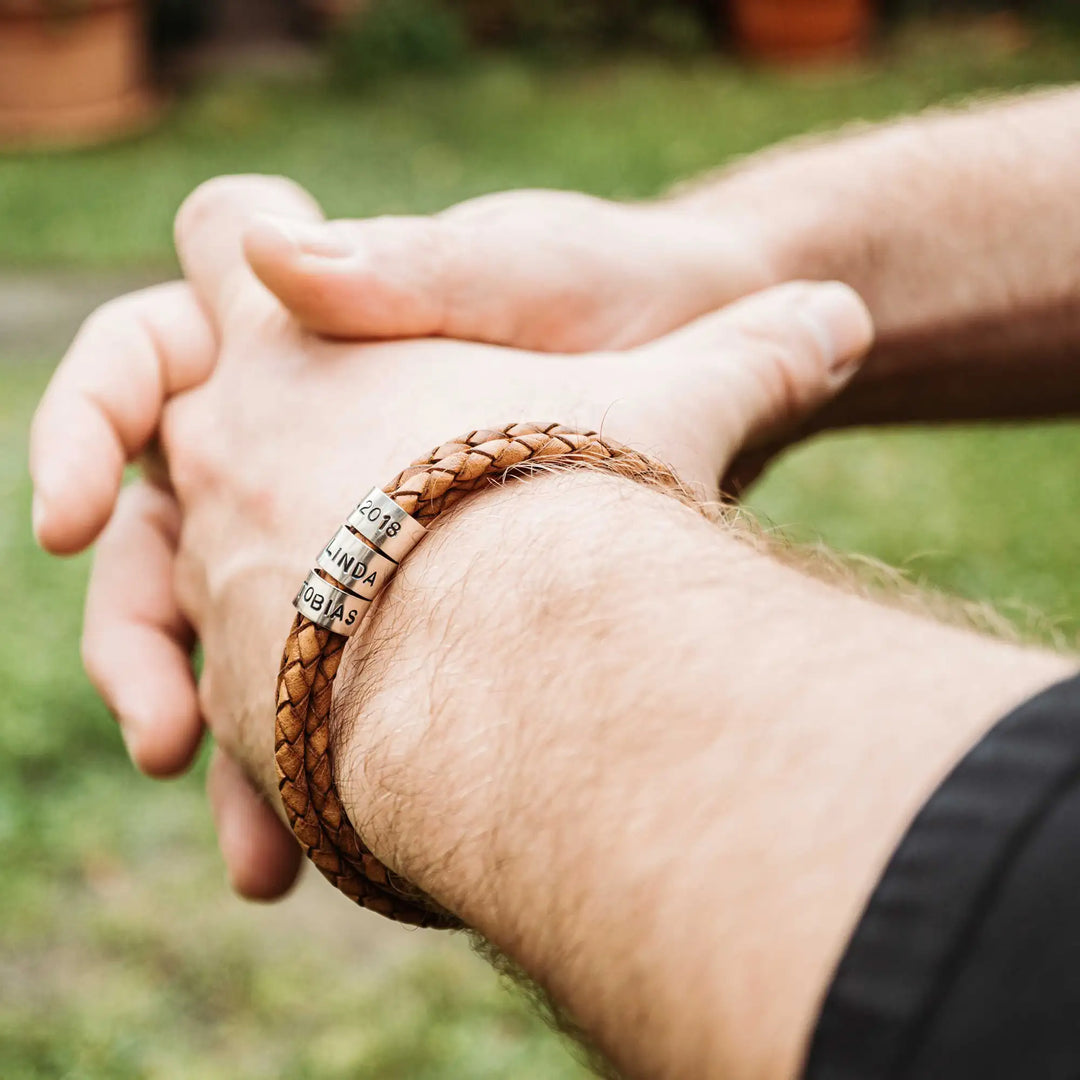 Ein geflochtenes Armband aus hellem braunem Leder im Wickelarmband Look, personalisiert mit Namen Gravur auf Sterling Silber 925 Perlen. Das Armband lässt sich mit einem Karabiner aus Edelstahl verschließen.