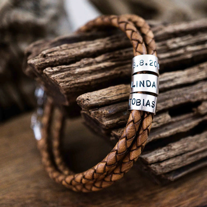 Ein geflochtenes Armband aus hellem braunem Leder im Wickelarmband Look, personalisiert mit Namen Gravur auf Sterling Silber 925 Perlen. Das Armband lässt sich mit einem Karabiner aus Edelstahl verschließen.
