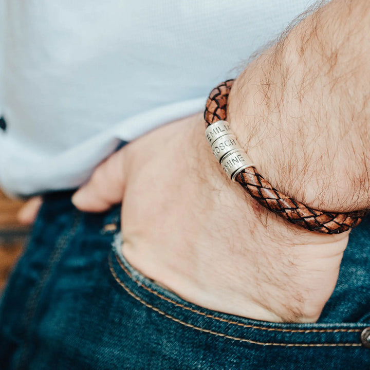Ein dickes, geflochtenes Armband für Herren aus braunem Leder, personalisiert mit Gravur von Namen und Datum auf Sterling Silber 925 Perlen. Das Armband lässt sich mit einem stabilen Verschluss aus Edelstahl verschließen.