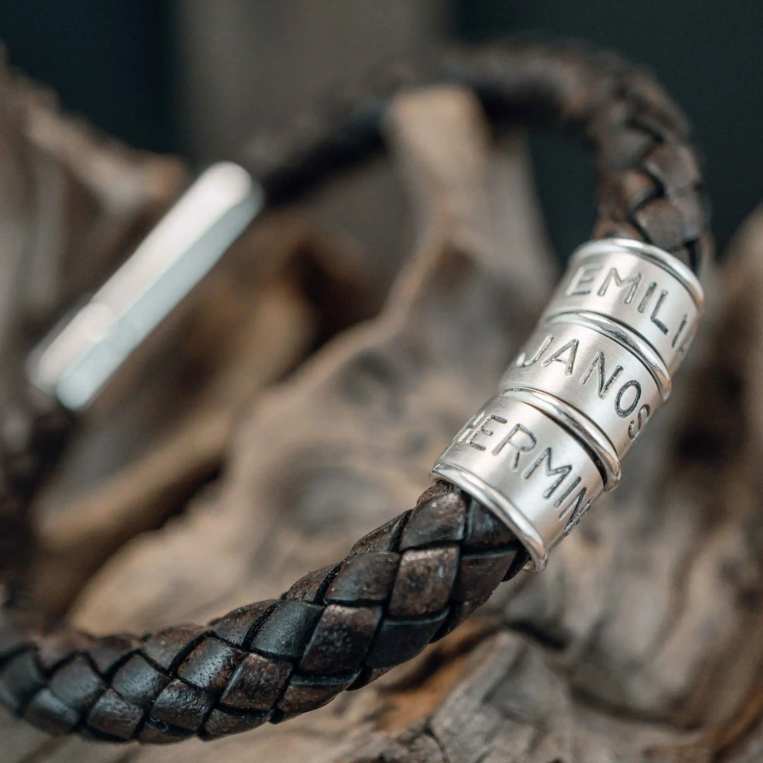 Ein dickes, geflochtenes Armband für Herren aus braunem dunklen Leder, personalisiert mit Gravur von Namen und Datum auf Sterling Silber 925 Perlen. Das Armband lässt sich mit einem stabilen Verschluss aus Edelstahl verschließen.