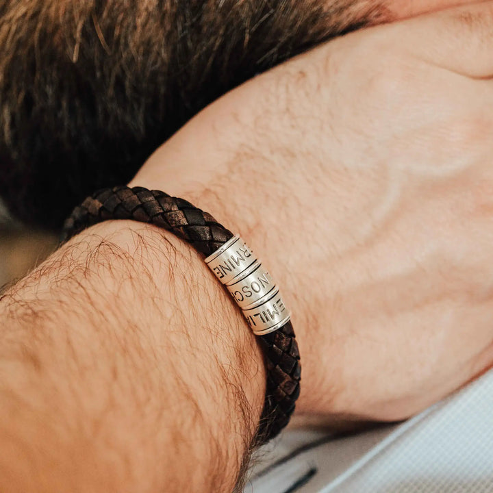 Ein dickes, geflochtenes Armband für Herren aus braunem dunklen Leder, personalisiert mit Gravur von Namen und Datum auf Sterling Silber 925 Perlen. Das Armband lässt sich mit einem stabilen Verschluss aus Edelstahl verschließen.
