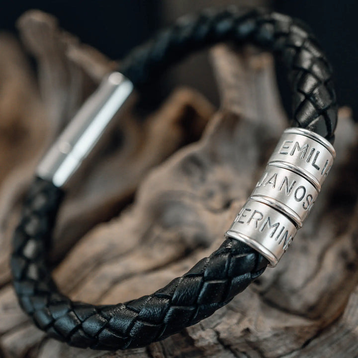 Ein dickes, geflochtenes Armband für Herren aus schwarzem Leder, personalisiert mit Gravur von Namen und Datum auf Sterling Silber 925 Perlen. Das Armband lässt sich mit einem stabilen Verschluss aus Edelstahl verschließen.