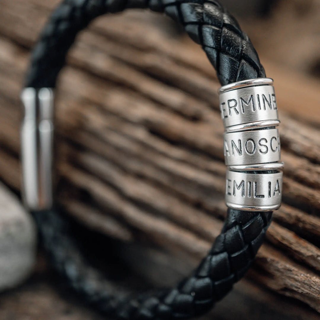 Ein dickes, geflochtenes Armband für Herren aus schwarzem Leder, personalisiert mit Gravur von Namen und Datum auf Sterling Silber 925 Perlen. Das Armband lässt sich mit einem stabilen Verschluss aus Edelstahl verschließen.