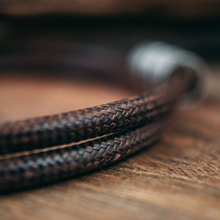 Eine vegane Halskette für Männer aus braunem Synthetik/Baumwoll-Band. Die Kette für Herren ist personalisiert mit Gravur von Namen oder Datum auf zylindrischen Sterling Silber 925 Perlen. Das Kette lässt sich mit einem stabilen Karabiner Verschluss aus Edelstahl verschließen.