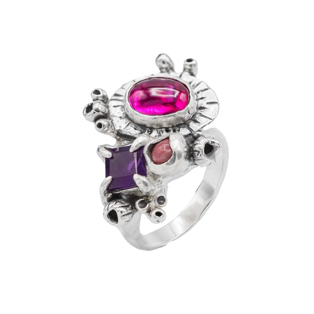 Ring mit 3 Steinen aus Silber. Die Steine sind ein eckiger lila Amethyst, ein ovaler pinker Korund und ein runder rosa Rhodonit. Der Naturschmuck Ring ist rustikal und üppig mit Knospen verziert.