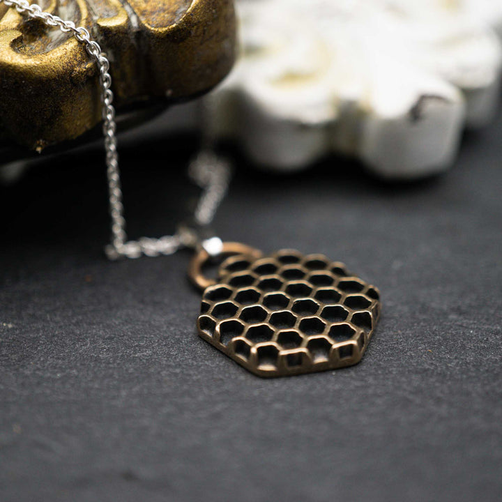Golden honeycomb bee necklace made of bronze