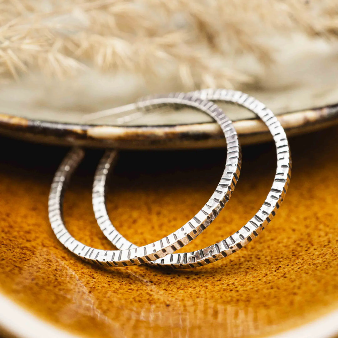 Creolen aus Silber 925. Die mittelgroßen Ohrring Creolen aus Silber sind handefertigt mit organischer Textur. Zeitlos, vielseitig, passt zu allem - echte Silberschmiede Arbeit.