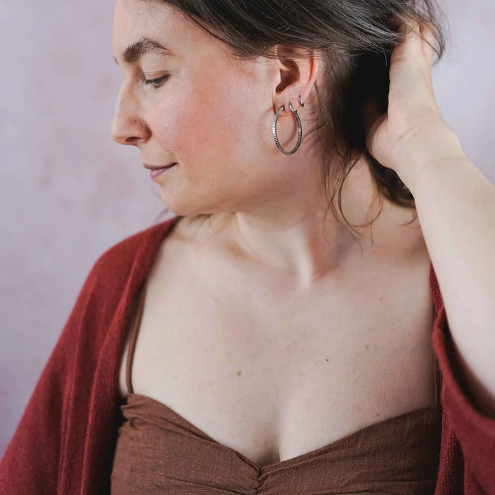 Creolen aus Silber 925. Die mittelgroßen Ohrring Creolen aus Silber sind handefertigt mit organischer Textur. Zeitlos, vielseitig, passt zu allem - echte Silberschmiede Arbeit.