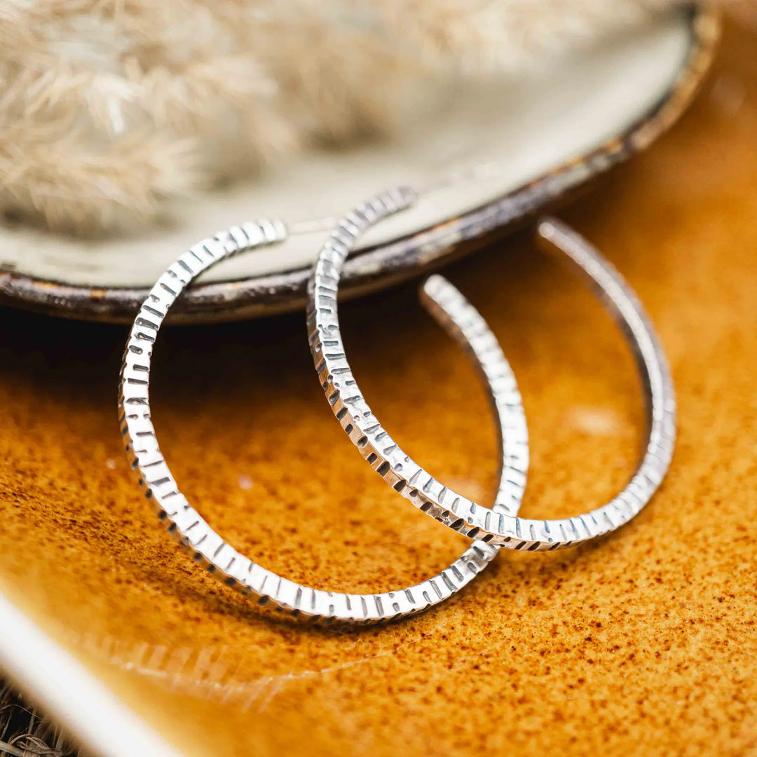 Creolen aus Silber 925. Die mittelgroßen Ohrring Creolen aus Silber sind handefertigt mit organischer Textur. Zeitlos, vielseitig, passt zu allem - echte Silberschmiede Arbeit.