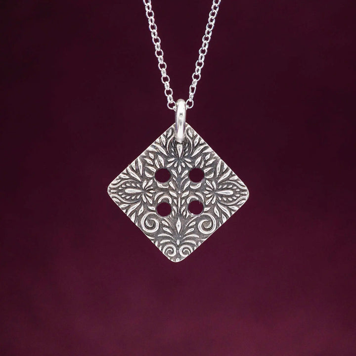 Freundschaftskette aus Silber 925 mit einem Knopf Anhänger an einer Kette. Der Knopf Anhänger ist eckig und mit einem floralen Muster versehen. Der eckige Knopf steht für Zusammenhalt, auch wenn nicht immer alles ganz "rund" läuft.