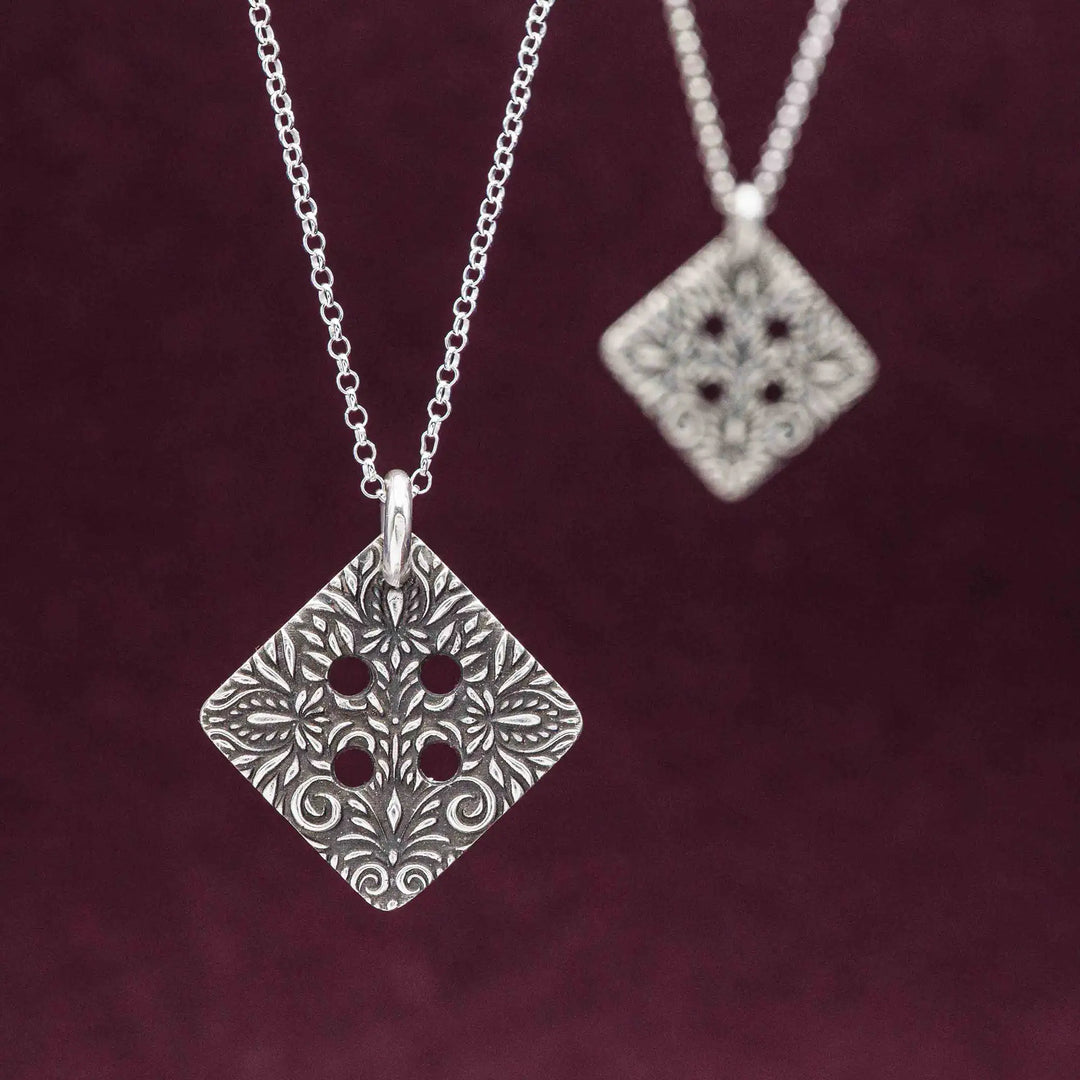Freundschaftskette aus Silber 925 mit einem Knopf Anhänger an einer Kette. Der Knopf Anhänger ist eckig und mit einem floralen Muster versehen. Der eckige Knopf steht für Zusammenhalt, auch wenn nicht immer alles ganz "rund" läuft.