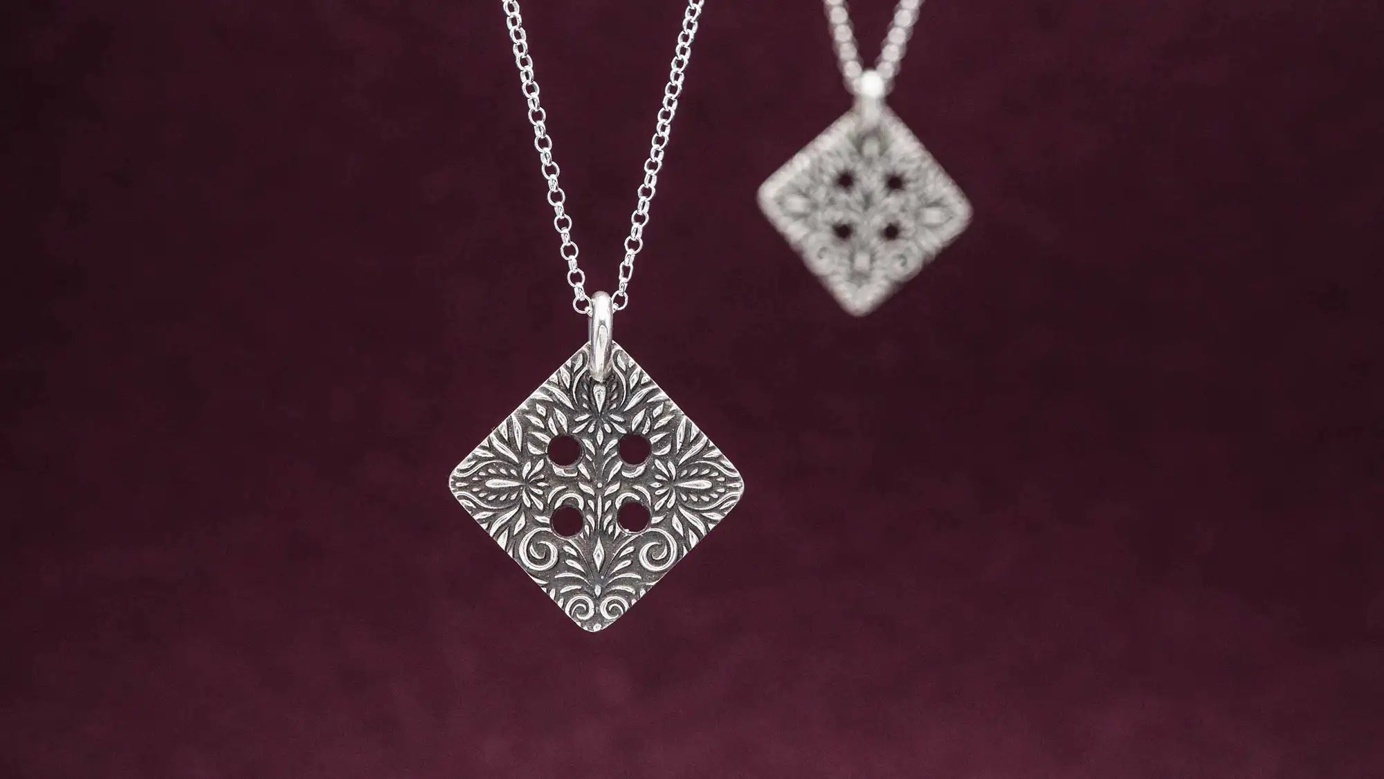 Freundschaftskette aus Silber 925 mit einem Knopf Anhänger an einer Kette. Der Knopf Anhänger ist eckig und mit einem floralen Muster versehen. Der eckige Knopf steht für Zusammenhalt, auch wenn nicht immer alles ganz "rund" läuft.
