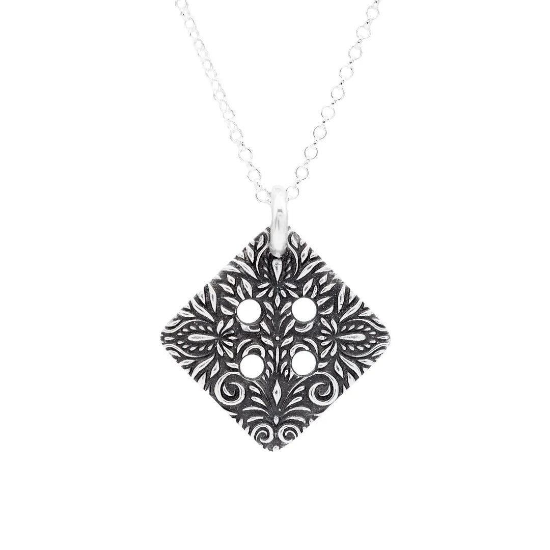 Freundschaftskette aus Silber 925 mit einem Knopf Anhänger an einer Kette. Der Knopf Anhänger ist eckig und mit einem floralen Muster versehen. Der eckige Knopf steht für Zusammenhalt, auch wenn nicht immer alles ganz "rund" läuft.