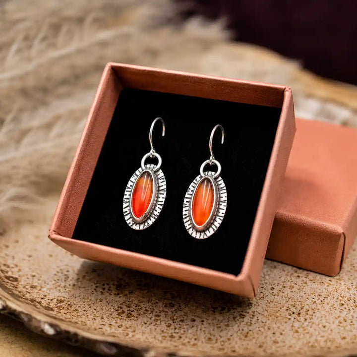 Handgefertigte Ohrringe in Rot-Orange mit ovalen Karneolen und rustikaler Silberstruktur in Geschenkbox