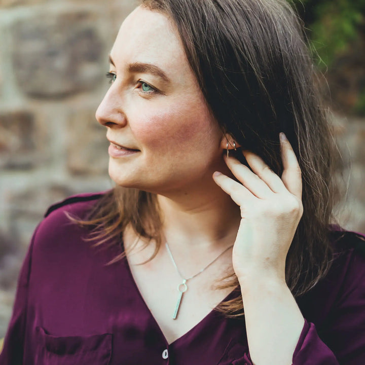 Eine Halskette mit Gravur für Frauen. Sie besteht aus einem Anhänger an einem Ring und einer Kette aus Sterling Silber 925. Die Kette für Damen ist auf dem ca 4cm langen, rechteckigen Anhänger personalisiert mit Gravur von Namen oder Datum auf allen 4 Seiten des Anhängers. Die Kette lässt sich mit einem silbernen Karabiner aus Edelstahl verschließen.