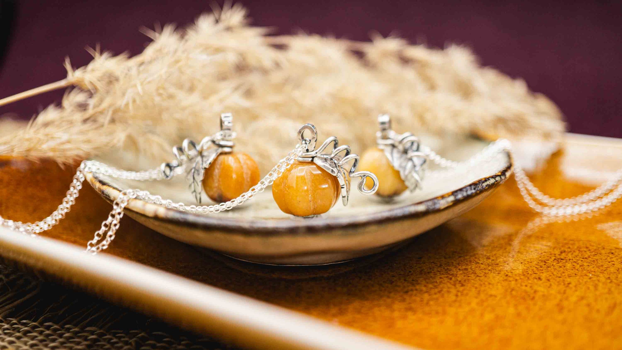 Handgefertigte Kette mit Kürbis aus Silber 925. Der Kürbis besteht aus dem Edelstein gelbe Topas Jade und ist mit Blatt und Ranken-Elementen aus Silber verziert.
