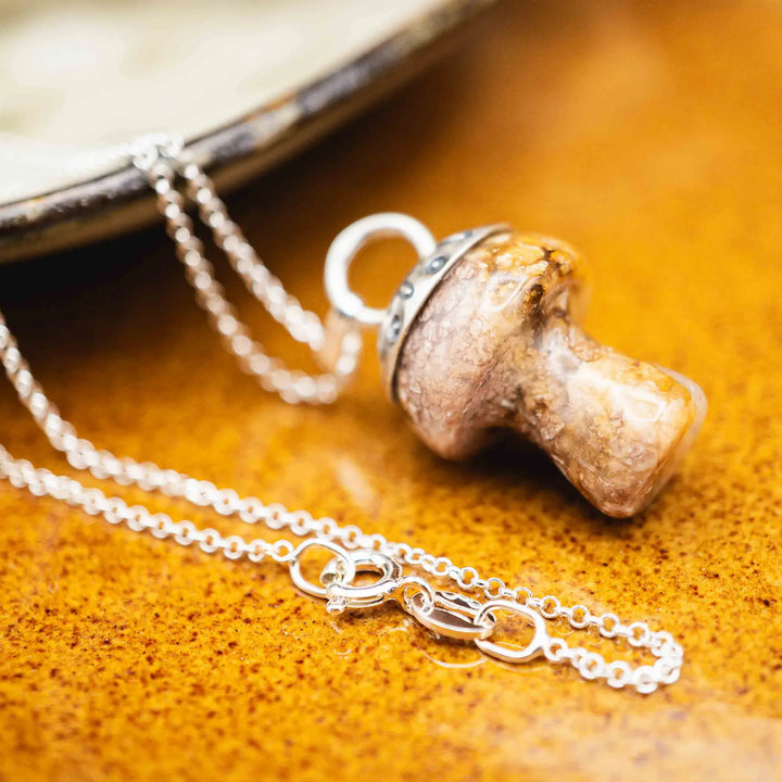 Kette mit Pilz aus Silber 925. Der Pilz ist ein Jaspis Edelstein in Rosa und Gelb gefleckt. Die Naturstein Kette mit Silberkappe ist eine Silberschmiedearbeit.