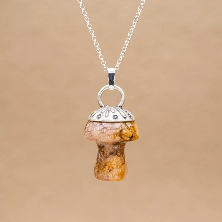 Kette mit Pilz aus Silber 925. Der Pilz ist ein Jaspis Edelstein in Rosa und Gelb gefleckt. Die Naturstein Kette mit Silberkappe ist eine Silberschmiedearbeit.