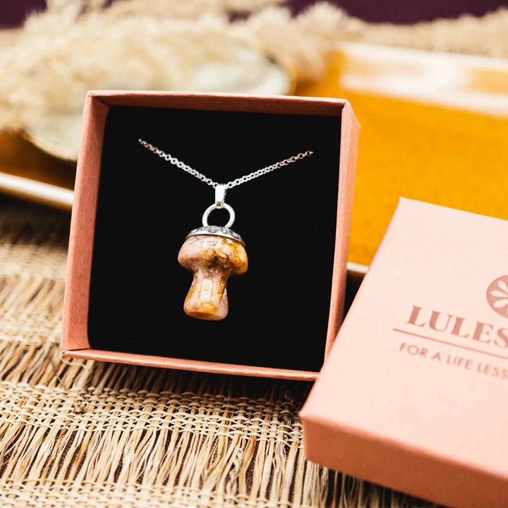 Kette mit Pilz aus Silber 925. Der Pilz ist ein Jaspis Edelstein in Rosa und Gelb gefleckt. Die Naturstein Kette mit Silberkappe ist eine Silberschmiedearbeit.