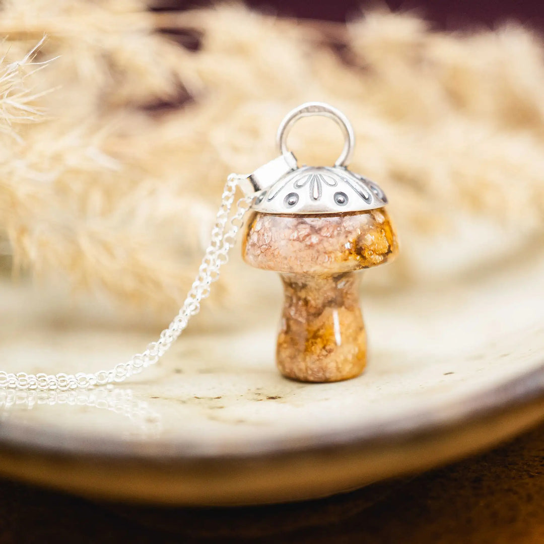 Kette mit Pilz aus Silber 925. Der Pilz ist ein Jaspis Edelstein in Rosa und Gelb gefleckt. Die Naturstein Kette mit Silberkappe ist eine Silberschmiedearbeit.