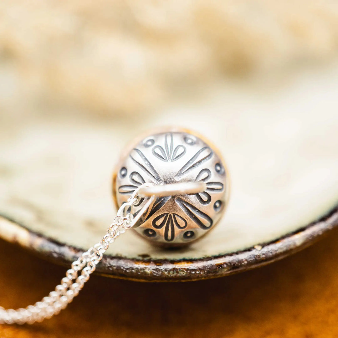 Kette mit Pilz aus Silber 925. Der Pilz ist ein Jaspis Edelstein in Rosa und Gelb gefleckt. Die Naturstein Kette mit Silberkappe ist eine Silberschmiedearbeit.