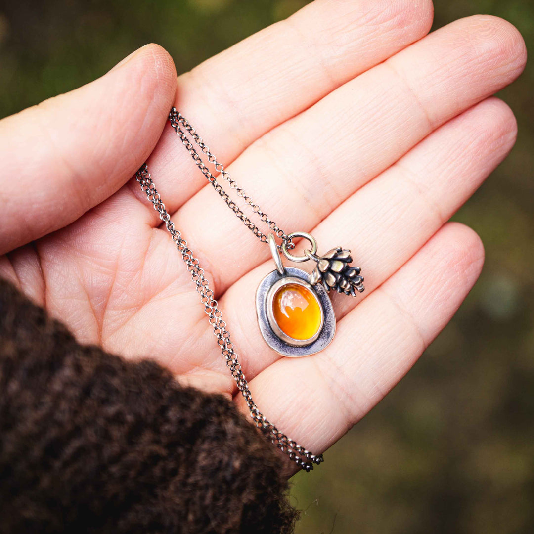 Kette aus Silber 925 mit Karneol & Tannenzapfen Charm Anhänger. Die zarte Silberkette mit kleinem Tannenzapfen Anhänger und rotem Karneol, eingefasst in Sterling Silber 925, ist besonderer handgefertigter Silberschmuck für die goldene Jahreszeit. Ein einzigartiges Geschenk für die Frau, die Waldspaziergänge und Natur liebt.