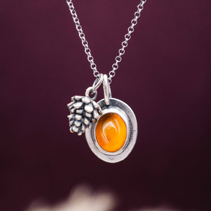 Herbstschmuck bestehend aus einer zarten Silberkette mit kleinem Tannenzapfen Anhänger und rotem Karneol, eingefasst in Sterling Silber 925.