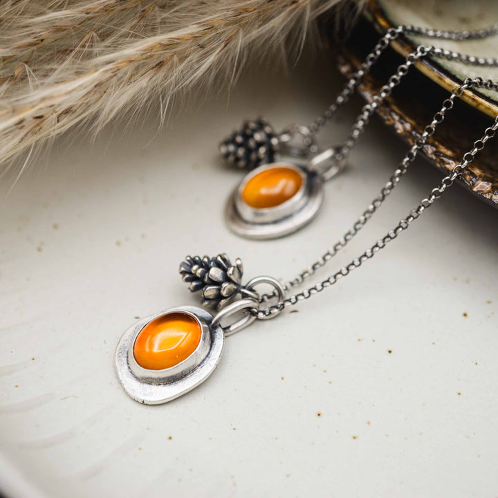 Zarte Silberkette mit kleinem Tannenzapfen Anhänger und rotem Karneol, eingefasst in Sterling Silber 925. Perfekter handgefertigter Silberschmuck für die goldene Jahreszeit.