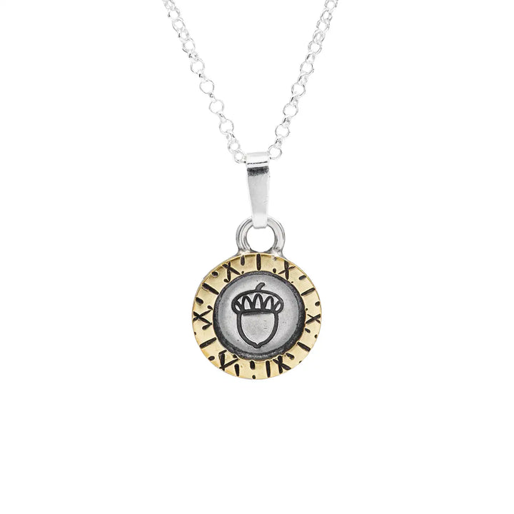 Eine kurze Silberkette aus Sterling Silber 925 mit einem kleinen gravierten Eichel Anhänger, eingerahmt von einem goldenem Rahmen.