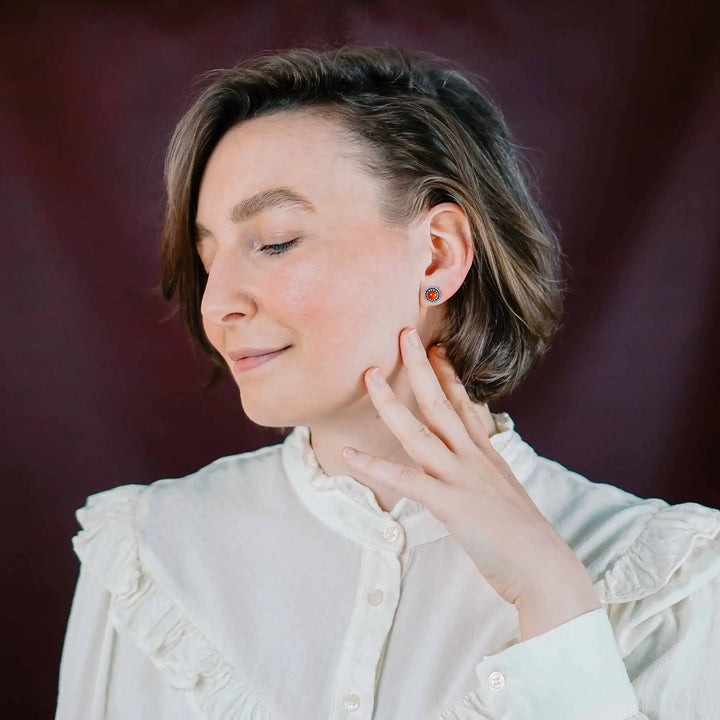 Handgefertigte Karneol Ohrstecker aus Sterling Silber 925 mit rundem Edelstein. Der leuchtend rote Karneol sitzt in einer patinierten Krone aus Silberspitze. Die kleinen Ohrstecker aus Silber sind minimalistischer Edelstein Schmuck, perfekt für Alltag und als Schmuck Geschenkidee für Frauen.