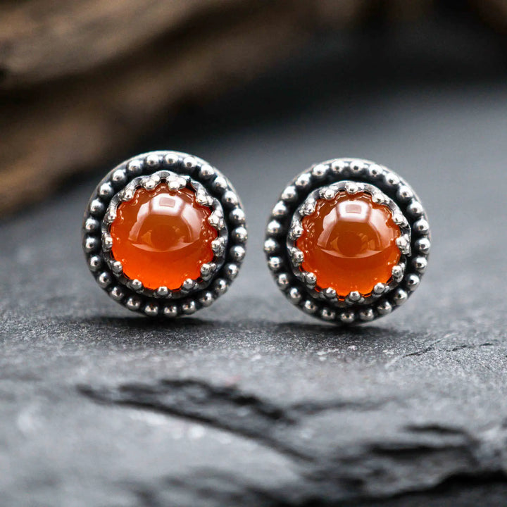 Handgefertigte Karneol Ohrstecker aus Sterling Silber 925 mit rundem Edelstein. Der leuchtend rote Karneol sitzt in einer patinierten Krone aus Silberspitze. Die kleinen Ohrstecker aus Silber sind minimalistischer Edelstein Schmuck, perfekt für Alltag und als Schmuck Geschenkidee für Frauen.