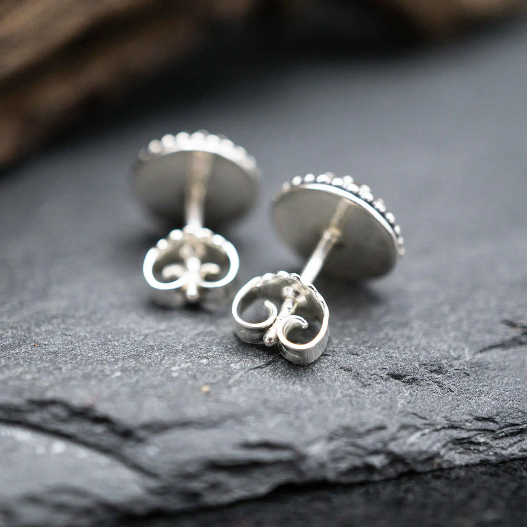 Handgefertigte Karneol Ohrstecker aus Sterling Silber 925 mit rundem Edelstein. Der leuchtend rote Karneol sitzt in einer patinierten Krone aus Silberspitze. Die kleinen Ohrstecker aus Silber sind minimalistischer Edelstein Schmuck, perfekt für Alltag und als Schmuck Geschenkidee für Frauen.