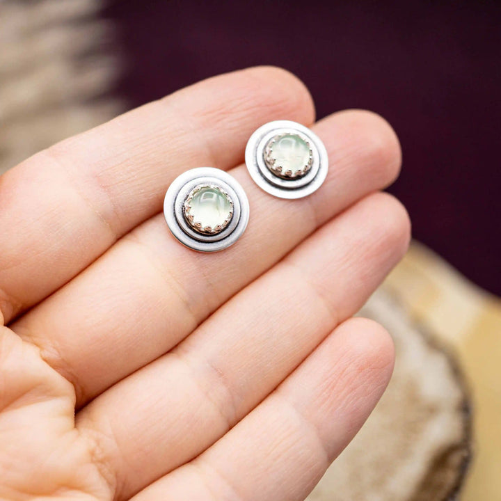 Handgefertigte Prehnit Ohrstecker aus Silber 925 mit rundem, hellgrünem Edelstein auf einer Handfläche