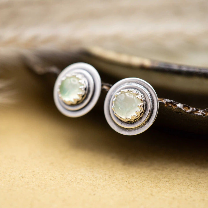 Handgemachte Silber Ohrstecker mit Prehnit Edelsteinen auf rustikaler Keramikschale fotografiert