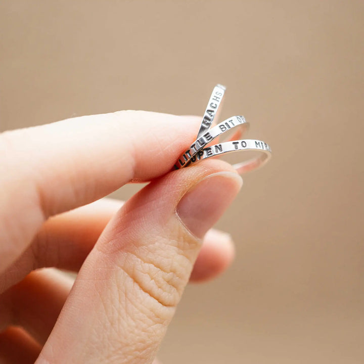 Schmaler Ring mit personalisierter Gravur aus Sterling Silber 925. In den dünnen Silberring sind Buchstaben und Texturen gehämmert nach individuellem Wunsch der Kundin. Auf einem Ring ist der Text “Open to Miracles” zu lesen, auf einem anderen ist der Spruch “A little bit of Madness is Key” eingraviert. Den dritten silbernen Ring zieren die Worte “Mädel, machs für dich”.