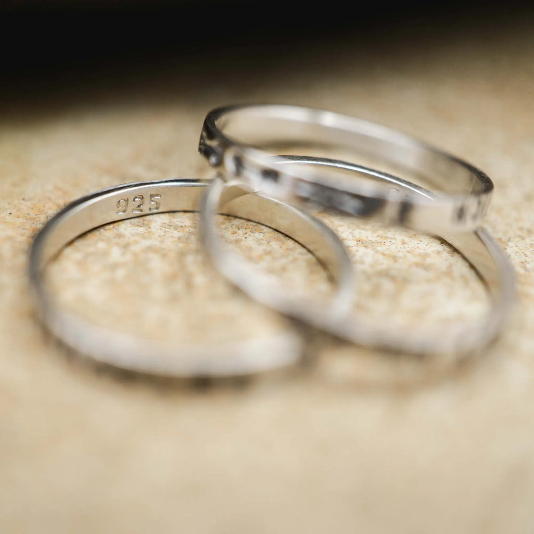 Schmaler Ring mit personalisierter Gravur aus Sterling Silber 925. In den dünnen Silberring sind Buchstaben und Texturen gehämmert nach individuellem Wunsch der Kundin. Auf einem Ring ist der Text “Open to Miracles” zu lesen, auf einem anderen ist der Spruch “A little bit of Madness is Key” eingraviert. Den dritten silbernen Ring zieren die Worte “Mädel, machs für dich”.