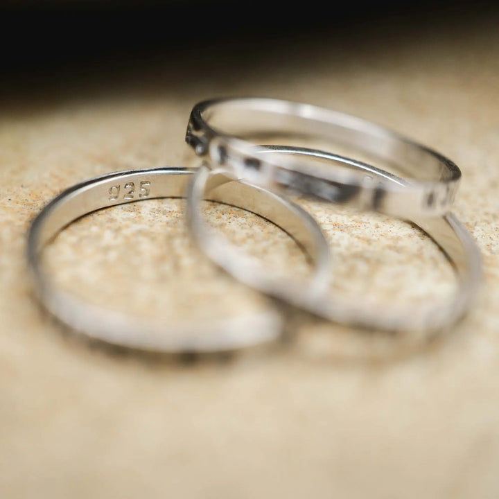 Schmaler Ring mit personalisierter Gravur aus Sterling Silber 925. In den dünnen Silberring sind Buchstaben und Texturen gehämmert nach individuellem Wunsch der Kundin. Auf einem Ring ist der Text “Open to Miracles” zu lesen, auf einem anderen ist der Spruch “A little bit of Madness is Key” eingraviert. Den dritten silbernen Ring zieren die Worte “Mädel, machs für dich”.