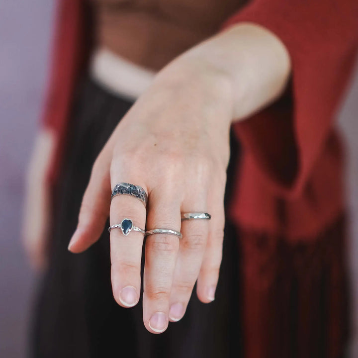 Ringe an einer Hand: Ein rustikaler Brutalist-Siegelring aus Silber, ein Ring aus Silber mit Labradorit Tropfen und zwei facettiert geschnitzte Hammerschlag Ringe aus Silber.